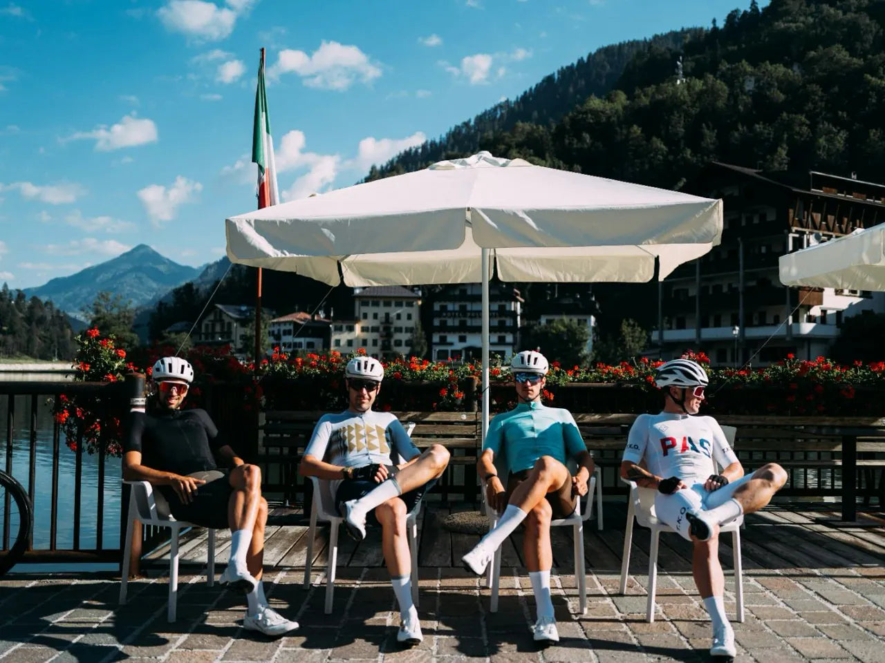 Ciclistes descansant en una terrassa al costat del llac d'Alleghe