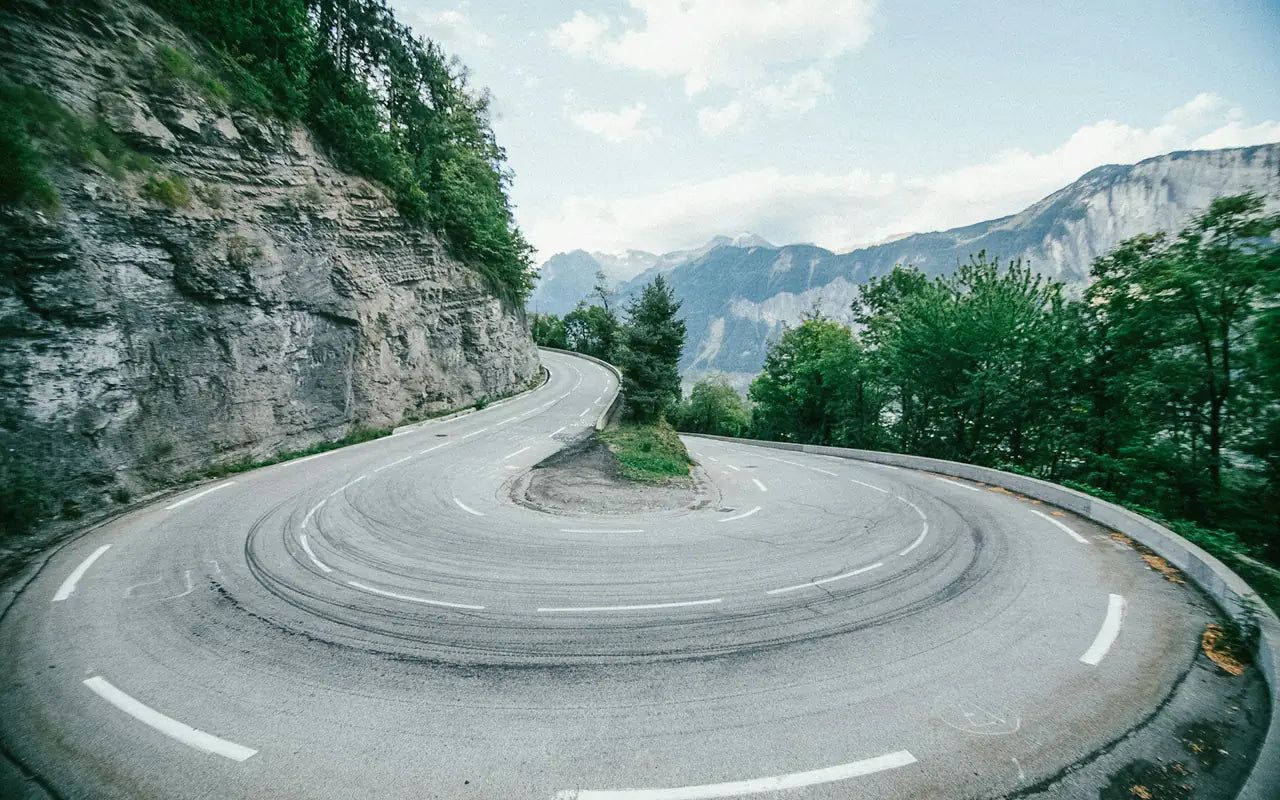 A hairpin bend carved into the cliff on an alpine road