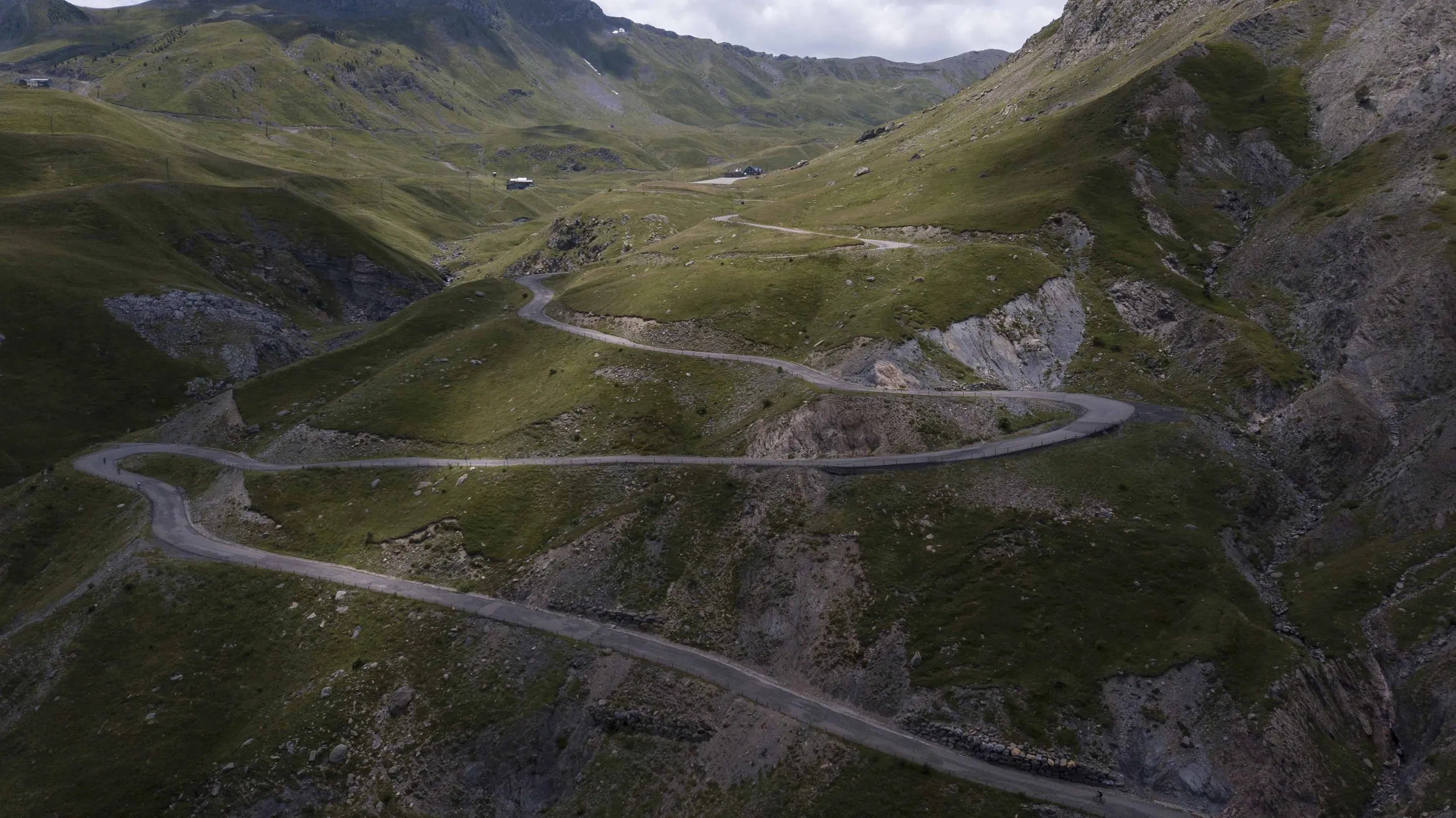 Luftfoto af en vej, der snor sig op gennem en dybgrøn dal i Pyrenæerne