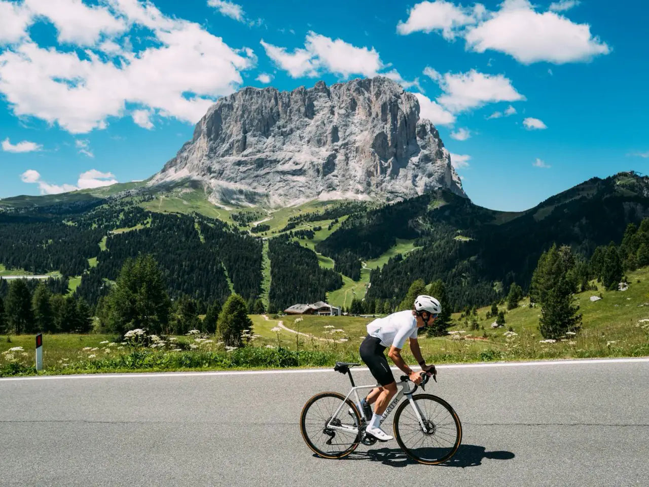 Un ciclista a la carretera d'un port sota el Sassolungo