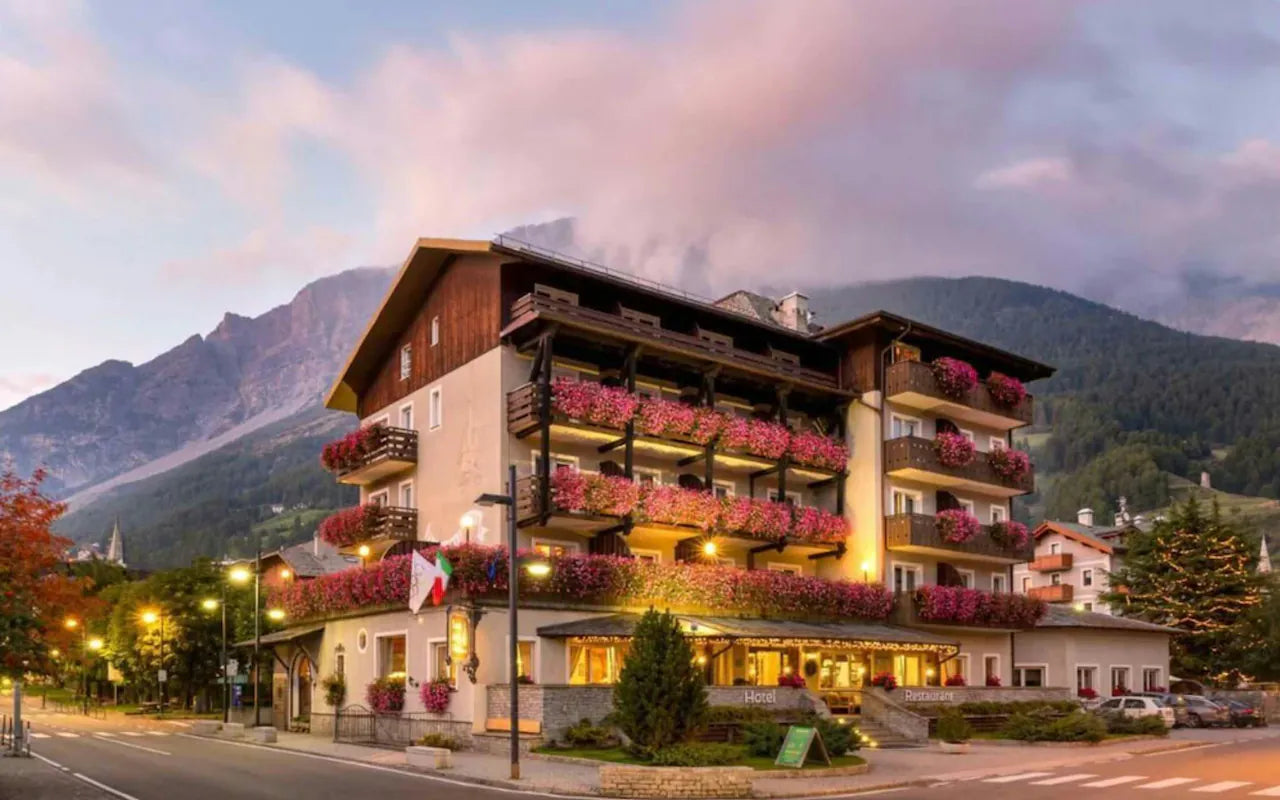 L'hotel Baita dei Pini a Bormio al capvespre, amb flors als balcons